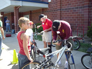 Frank Yates inspects bikes and Mike Goble repairs bikes